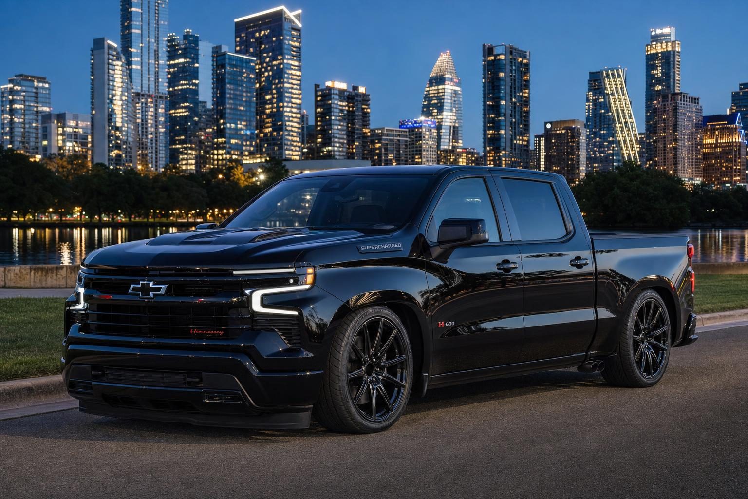 Black Hennessey H600 lowered Chevrolet Silverado on 24-inch wheels by Lady Bird Lake with the Austin skyline at night