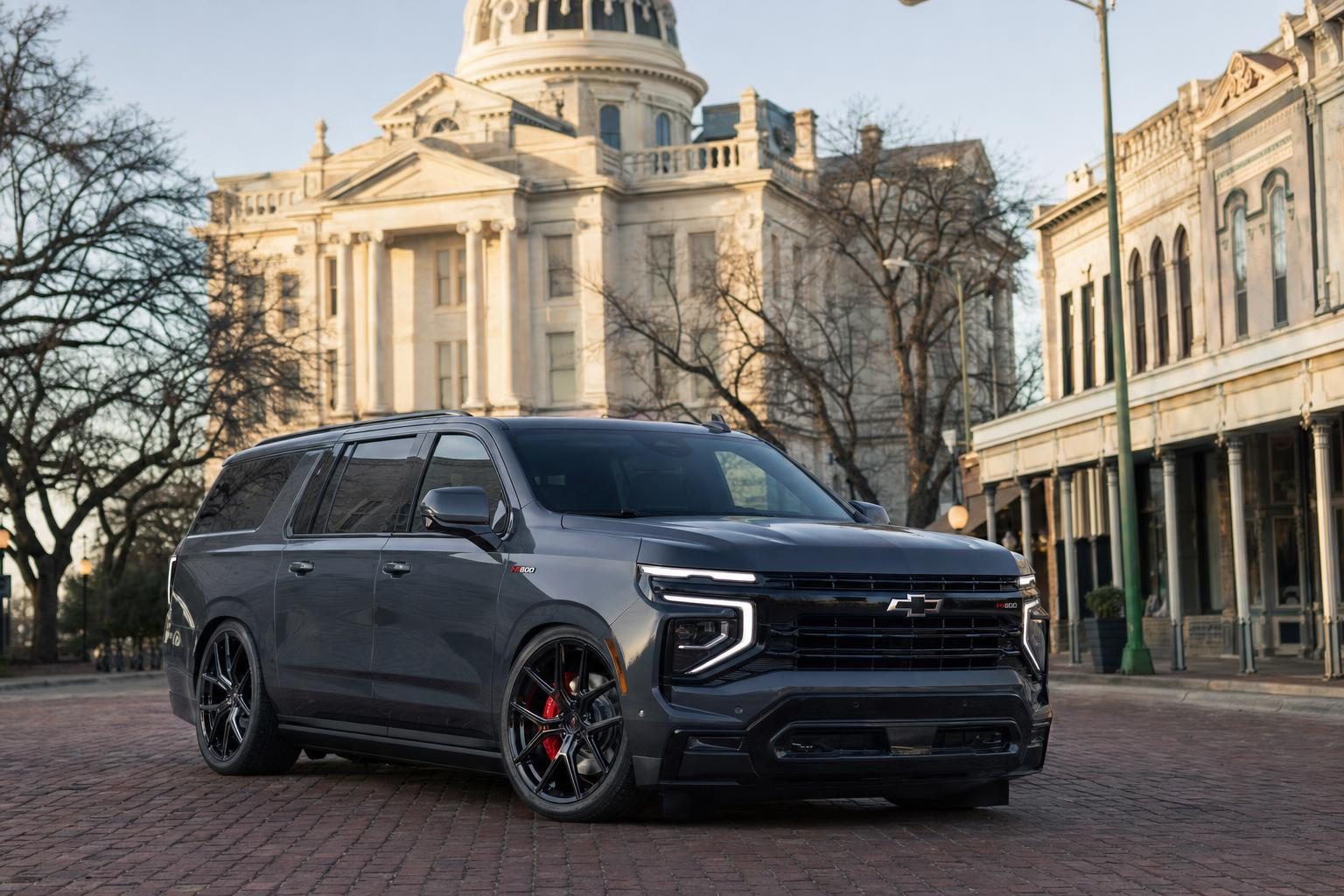 Dark gray Hennessey H600 Chevrolet Suburban beside the Williamson County Courthouse in Georgetown, Texas